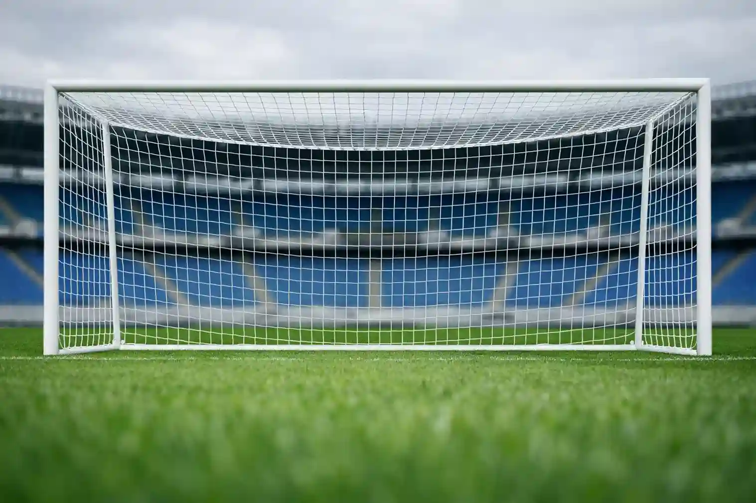 Portería de fútbol con red vista desde el interior del campo durante partido